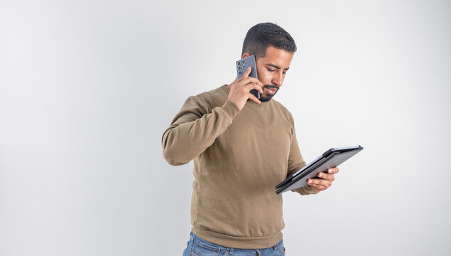 Man Multitasking on Phone and Tablet