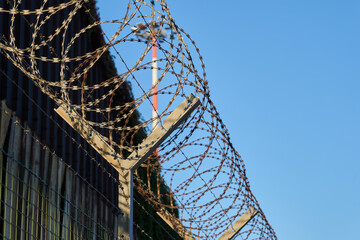 Barbed wire against a clear blue sky.