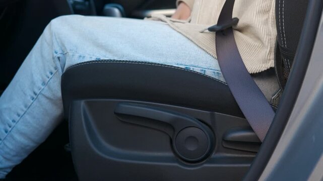 Passenger fastening seat belt in modern car. Detailed view showing responsible passenger carefully buckling seatbelt inside modern vehicle interior, highlighting critical road safety precautions