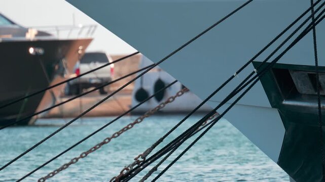Close up of ropes and metal chains securing a luxury yacht in port, with blurred water and boats in the background