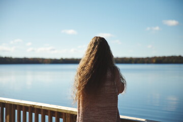 A woman standing in front of a lake in Canada. Lake on the Mountain located in Picton, Ontario.