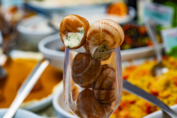 Cooked snails. Traditional French escargot served in a glass. Gourmet snails. Delicious escargot. French cuisine with escargot in shells. Traditional delicacy of cooked snails. Baked snails.