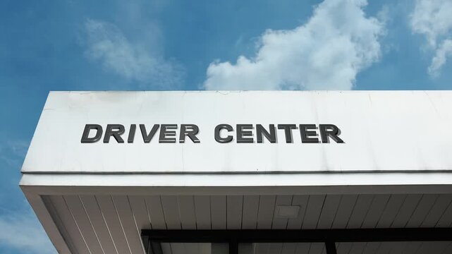 Driver Center word sign clearly displayed on the official government or commercial facility facade beneath a clear blue sky, signifying a location for licensing, vehicle registration, or professional