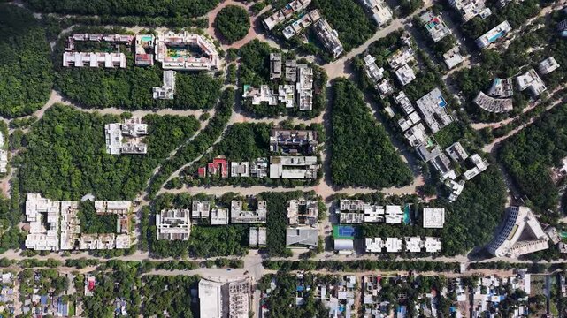 Aerial top down drone view of private community Aldea Zama in Tulum with houses and rooftops surrounded by green tropical vegetation on a sunny morning 