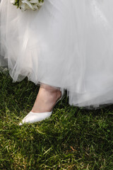 close-up, a woman's leg in a dress with a shoe on a grass background