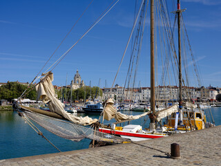Port of La Rochelle and a magnificent sailboat in foreground, We see the Big Clock which is an old city gate in background. La Rochelle is a commune in France, region Nouvelle Aquitaine