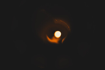 A detailed macro photo of a burning candle flame surrounded by dark, mystic ambience, evoking...