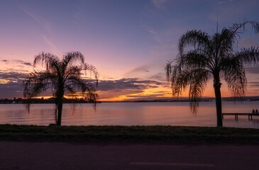 sunset over the lake with two coconut trees