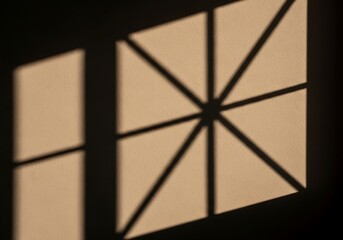 Window shadows cast geometric patterns on the beige textured wall