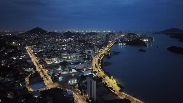 imagem a&eacute;rea da cidade de Vit&oacute;ria a noite, mostrando o canal de vit&oacute;ria, o porto, as principais vias da cidade e a regi&atilde;o comercial.