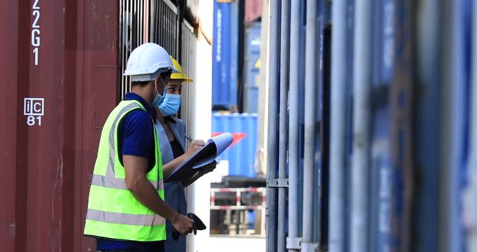 Foreman control loading containers box from factory to cargo freight ship. Container yard worker checking container at container yard warehouse. Shipping import export industry Logistics business.