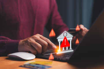 Cybersecurity warning concept showing hand using laptop and credit card with alert icons and bank...