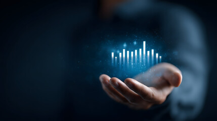 Holographic bar chart rising above a hand, representing business growth, investments, and financial progress.