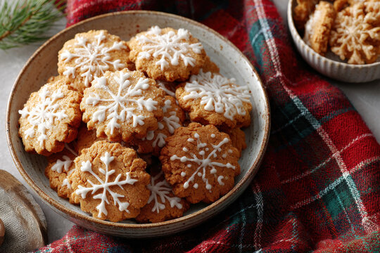 Round Gingerbread Cookies with White Icing Snowflake Pattern on Ceramic Plate Red Green Plaid Tablecloth - Powered by Adobe
