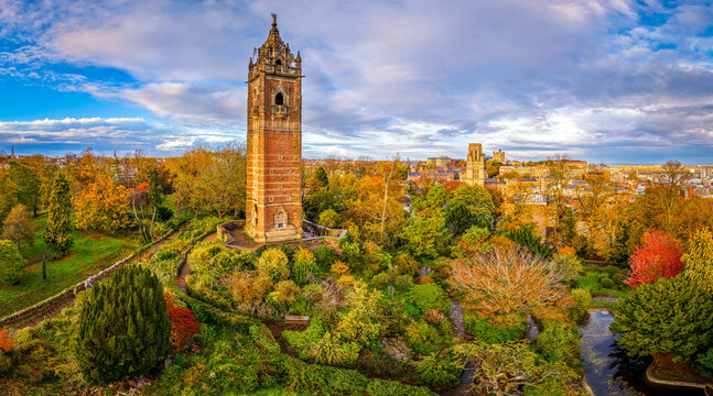 Cabot Tower surrounded by colorful autumn trees in Brandon Hill Park, with historic Bristol architecture in the background.