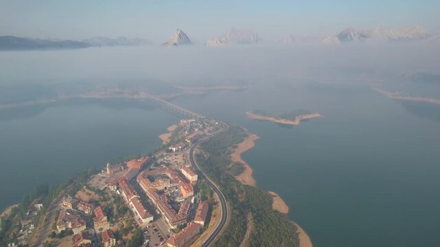 Landing aerial shot of Ria&ntilde;o town and reservoir under the smoke from forest fires. Monta&ntilde;a de Ria&ntilde;o and Mampodre Regional Park, Castile and Leon, Spain.