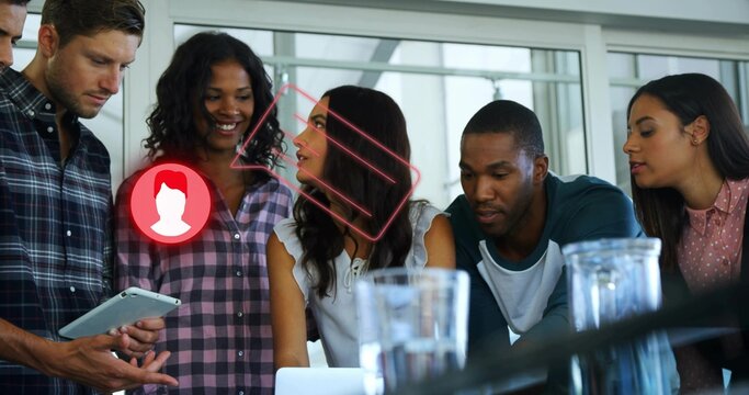 Reviewing content, colleagues working on tablet and laptop in office, with augmented reality icons