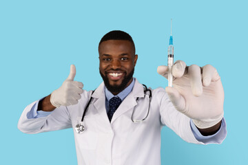 Vacination Campaign. Portrait Of Smiling Handsome Black Doctor With Syringe In Hand Looking At...