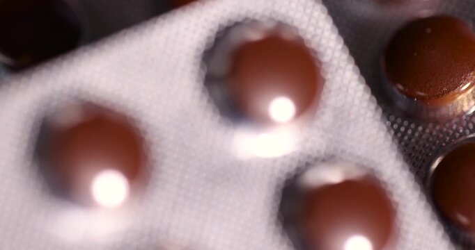 brown tablets in a plastic blister to ensure the safety of the medicine, several blisters with brown tablets