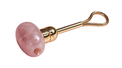 Pink rose quartz facial roller with gold handle isolated on transparent background