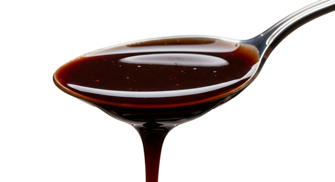 Viscous dark liquid honey or syrup slowly dripping from spoon