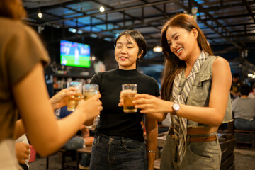 Friends cheering beer glasses enjoying night out