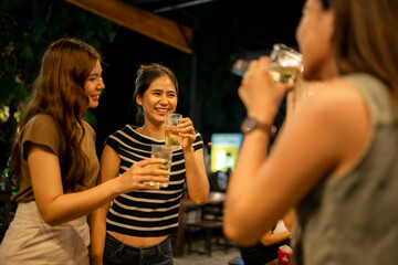 Diverse women friends enjoying a night out drinking