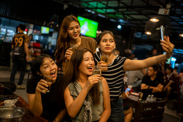 Asian women friends taking selfie drinking beer at bar
