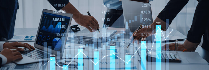 A diverse business team collaborates on financial analysis using modern tools. Charts and graphs display trends, enhancing strategic planning and productivity in the workplace. Scalp