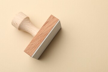 One wooden stamp on beige background, top view. Space for text