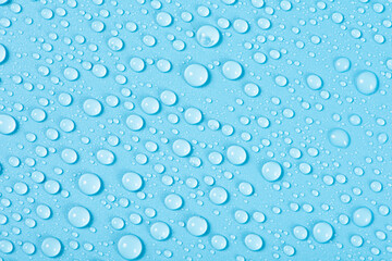 close up of water drops on blue background.