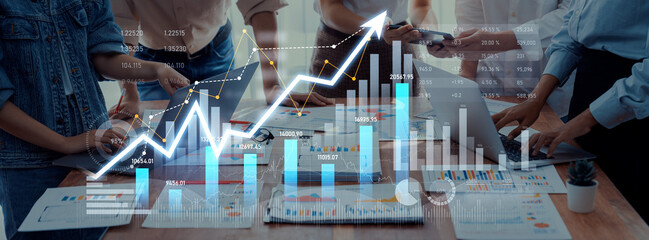 A diverse business team collaborates in an office, analyzing financial reports and statistics with a digital growth chart overlay for strategic decision making. Scalp