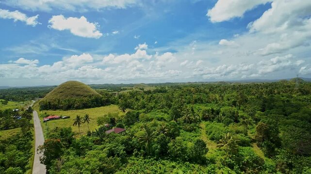 Chocolate Hills and tropical landscape under bright blue sky in Bohol Philippines