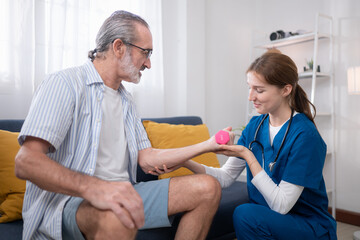 Obraz premium Female physiotherapist assisting an elderly man with arm strength training