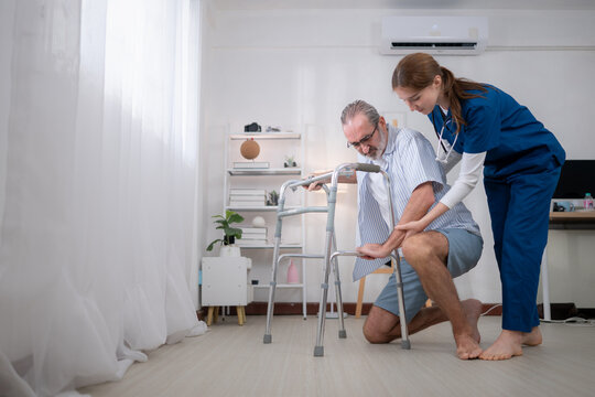 An elderly man holding a walking aid falls while learning to walk