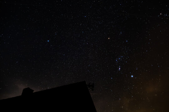 Beautiful night sky filled with stars and a rural cottage beneath it