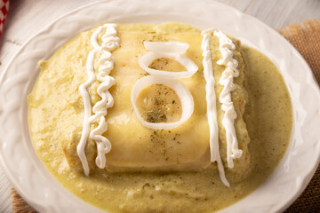 Green Enchiladas with creamy green sauce filled with shredded chicken meat and covered with melted cheese, in Mexico they are called Swiss Enchiladas. Very popular recipe in Mexican cuisine.