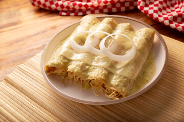 Green Enchiladas with creamy green sauce filled with shredded chicken meat and covered with melted cheese, in Mexico they are called Swiss Enchiladas. Very popular recipe in Mexican cuisine.