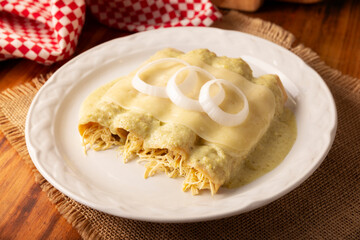 Green Enchiladas with creamy green sauce filled with shredded chicken meat and covered with melted cheese, in Mexico they are called Swiss Enchiladas. Very popular recipe in Mexican cuisine.