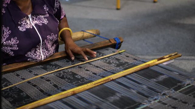 Making tenun ikat flores, Indonesia. An Indonesian woman weaving traditional flores fabric. Traditional weaving cotton in Indonesia.