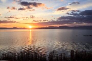 Obraz premium Golden Sunrise Over Calm Waters, Lake Biwa, Japan