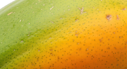 Close-up of a vibrant mango with green and orange hues on a
