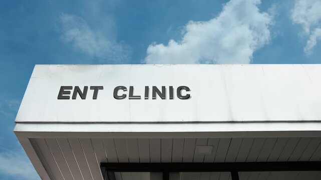 ENT Clinic word sign clearly displayed on the medical facility facade beneath a clear blue sky, signifying a health center specializing in ear, nose, and throat disorders.
