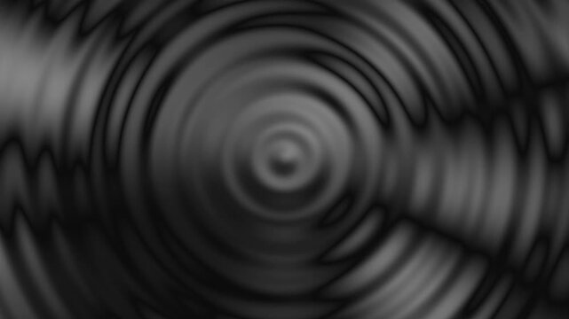 This monochromatic image features concentric circles radiating from a blurry central point. - Powered by Adobe