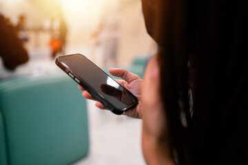 A woman is holding a cell phone in her hand