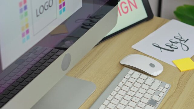 Designer workbench modern with logos on computer with handwritten sketches and sticky notes