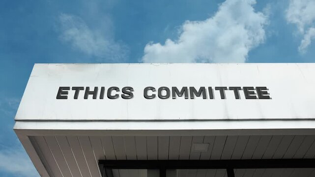 Ethics Committee word sign clearly displayed on the official institutional building facade beneath a clear blue sky, signifying the body responsible for maintaining moral and professional standards.