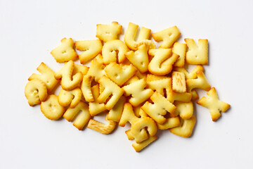 A pile of alphabet-shaped butter cookies arranged on a white background.