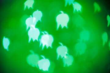 White lily of the valley bokeh on dark background – abstract small floral holiday background,...