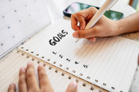 Close-up of a hand writing the word goals 2026 in a notebook. New year planning, goal setting and motivation concept